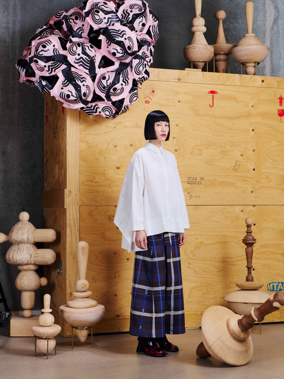 Henrik Vibskov Wind In Blouse in White worn side view, showing the relaxed silhouette, long sleeves and extended back hem.