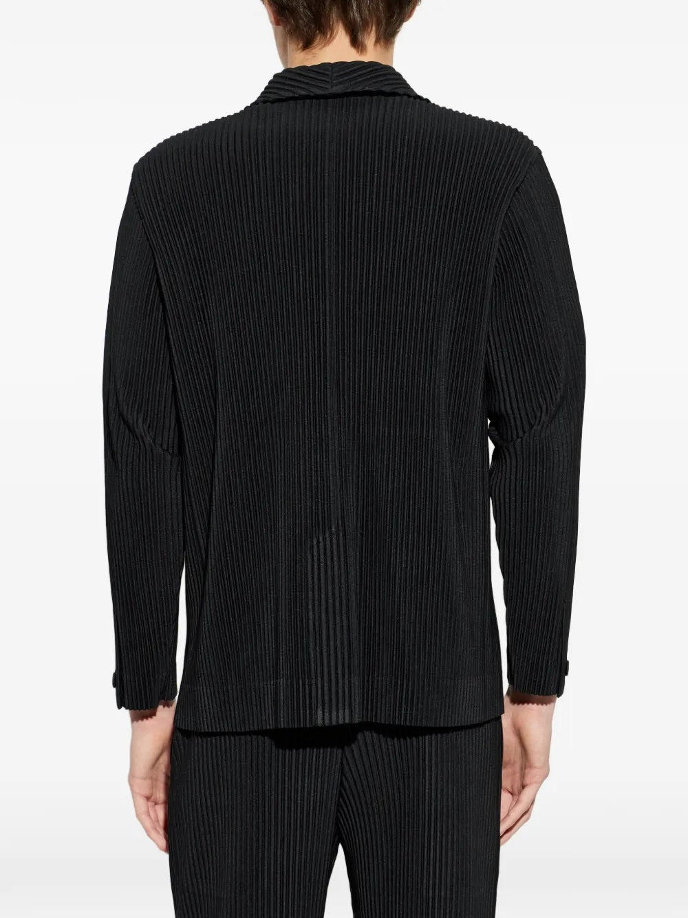 Homme Plissé Issey Miyake April SS26 Basic Jacket black, rear view on model showing the clean unlined back in all-over vertical pleats, dropped shoulders, and pleated trouser pairing