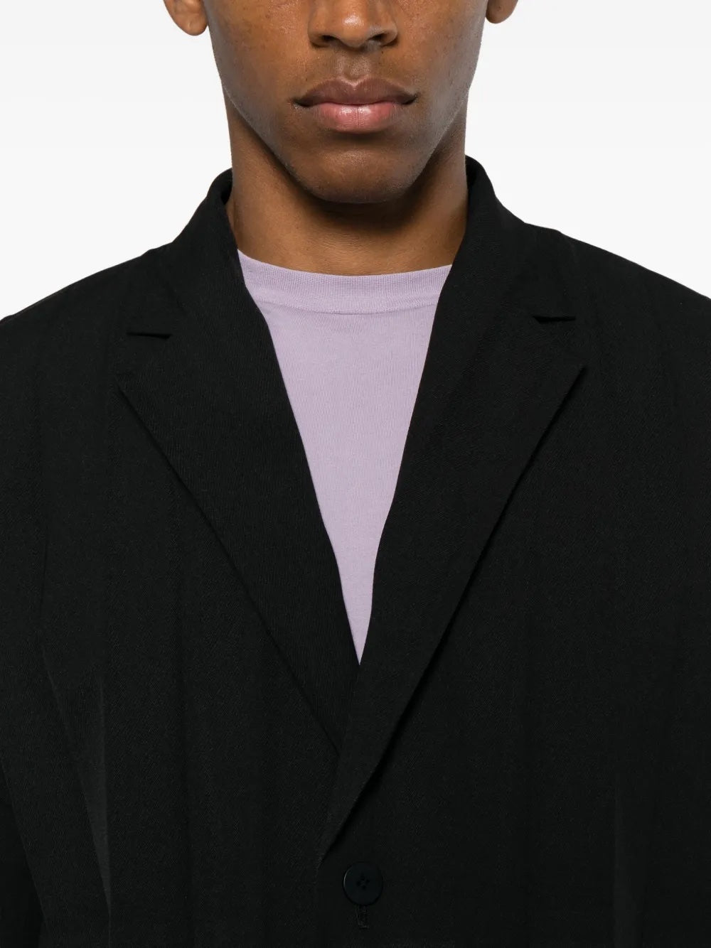 Close-up of the black blazer with large plissé from Homme Plissé Issey Miyake on a white background.