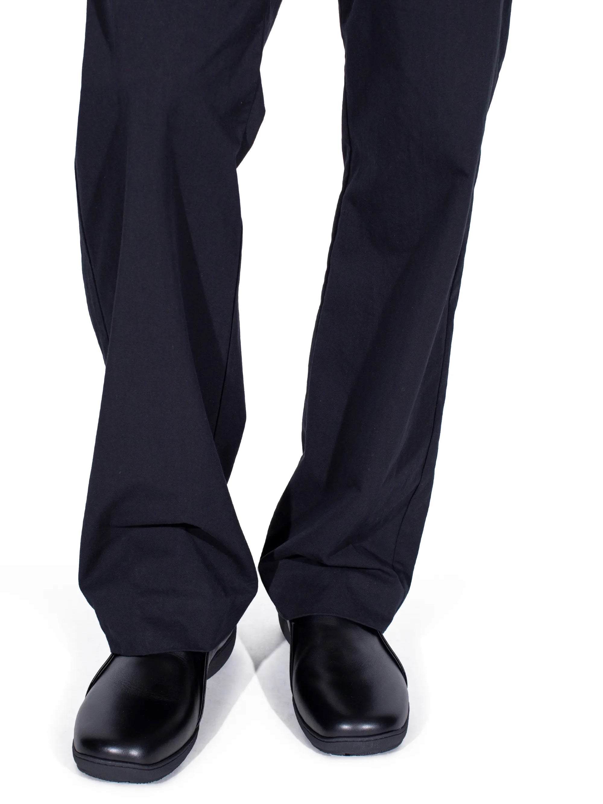 Model wearing Kiko Kostadinov Iskar Slip-On Shoes in black leather with minimal rounded toe and sleek slip-on silhouette