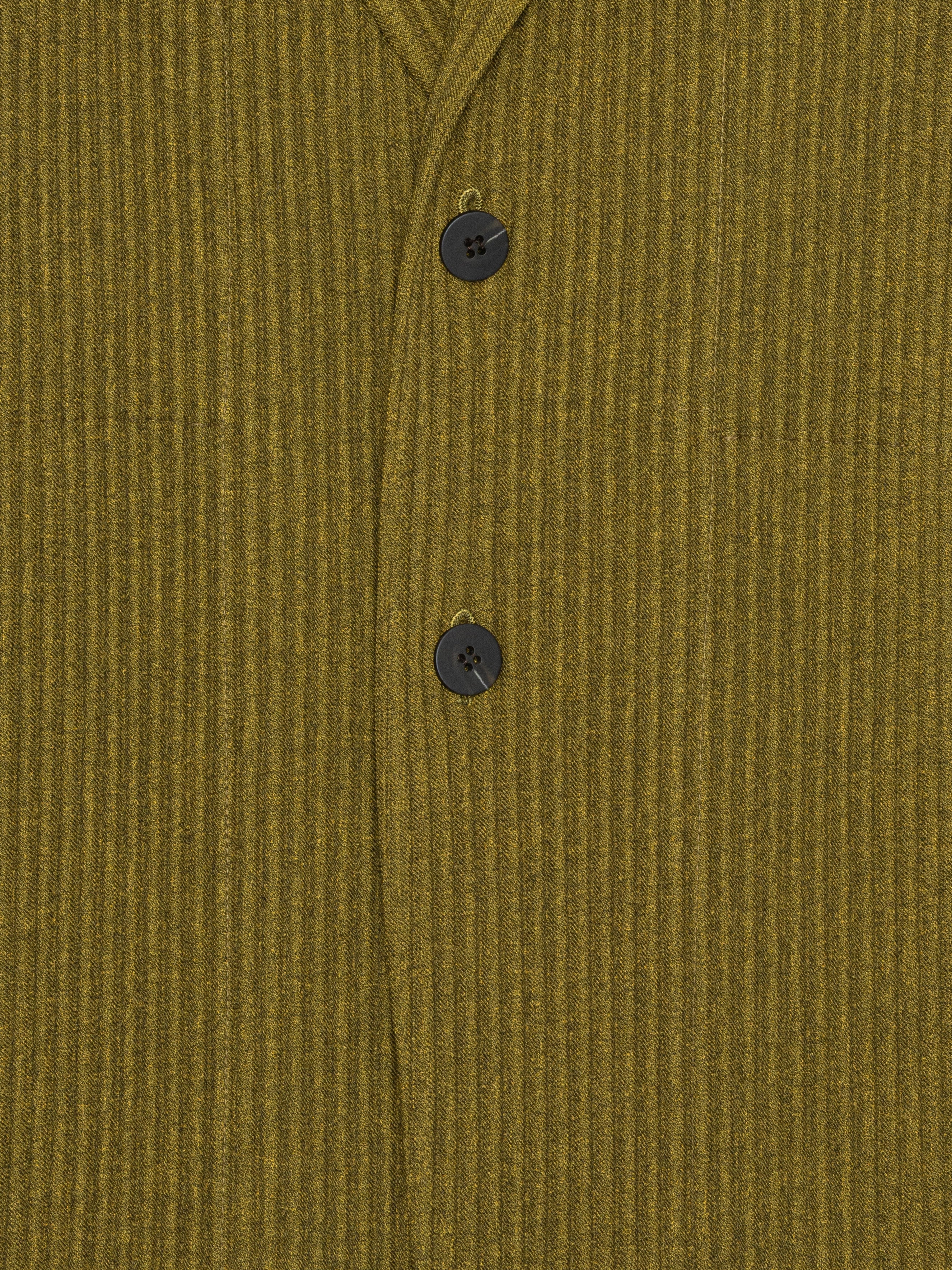 Close-up of a mossy yellow-green plissé blazer from Homme Plissé Issey Miyake