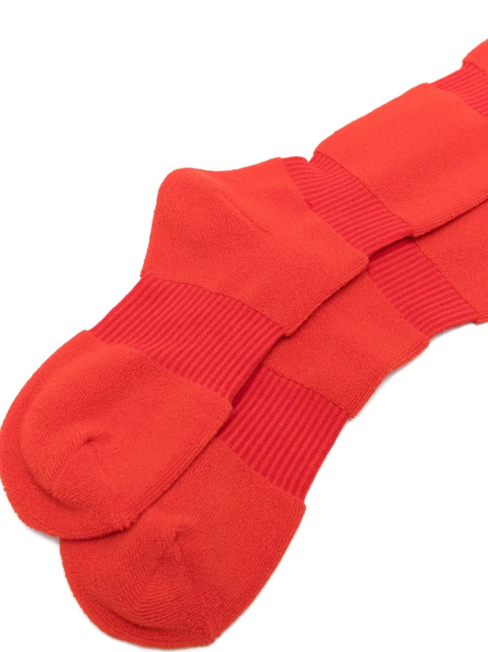 Closeup of the foot section of Issey Miyake October AW25 Pumped Socks Long in red, showing panelled ribbed knit construction and sculpted fit.