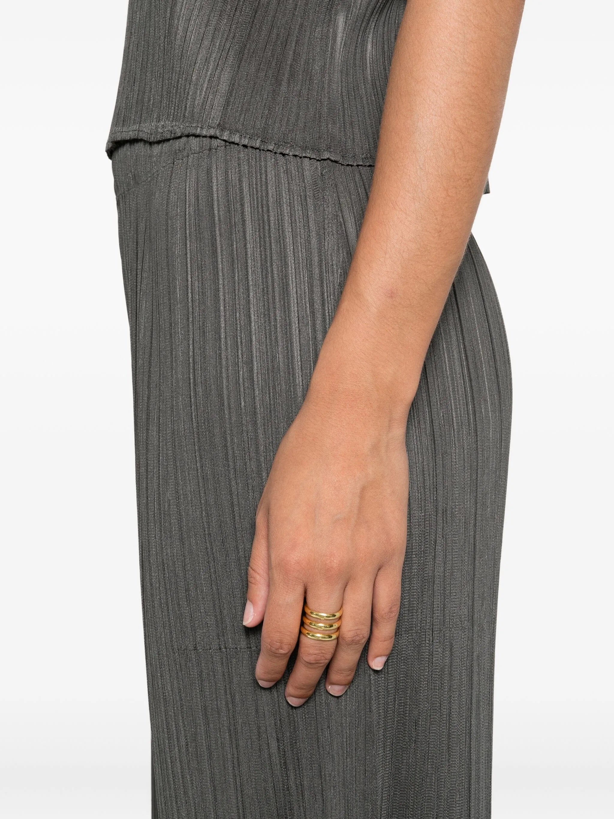 Person wearing a pleated pants on a plain background