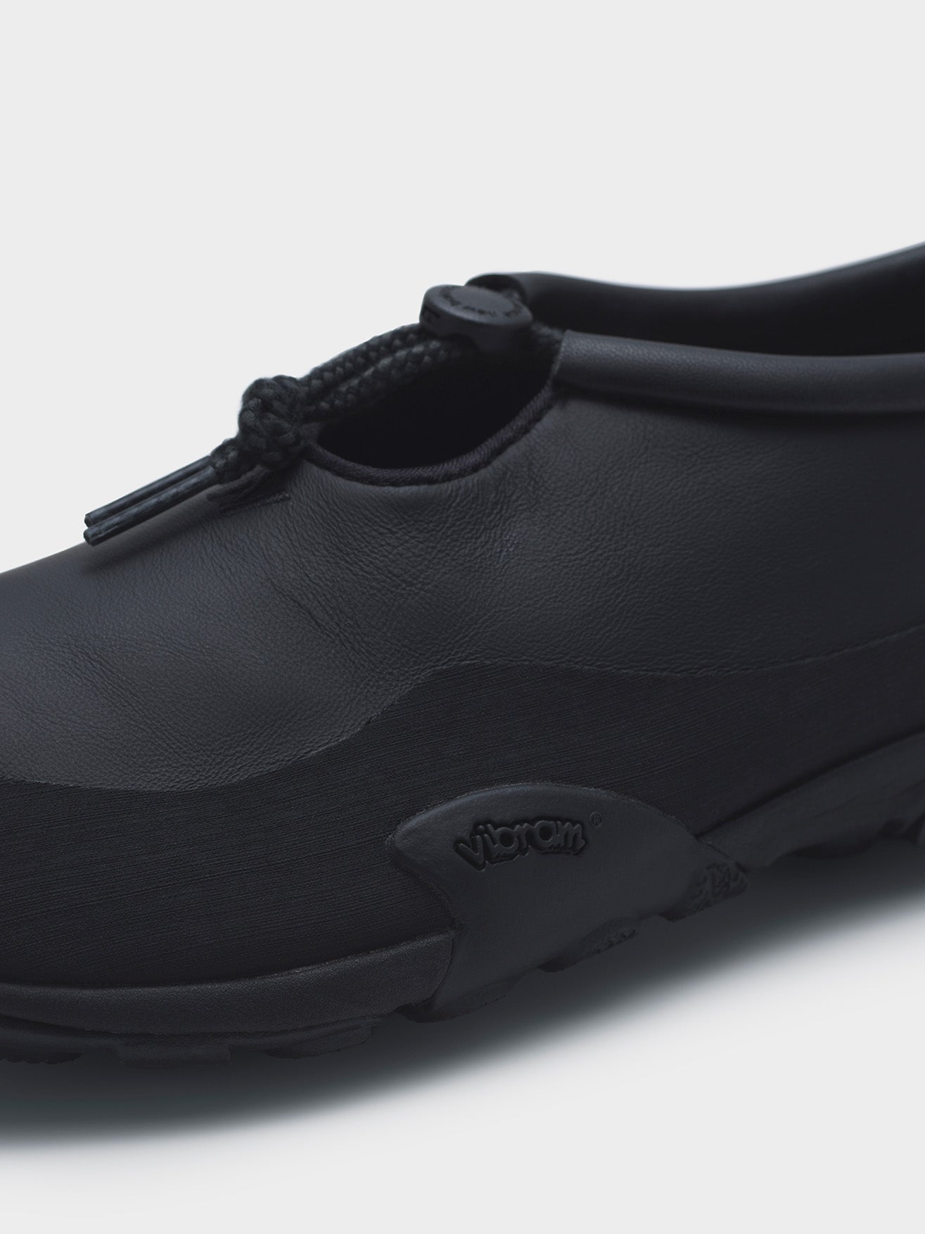 Junya Watanabe x New Balance MT10T sneakers in black, close-up of leather upper, rubber mudguard and Vibram® outsole detail
