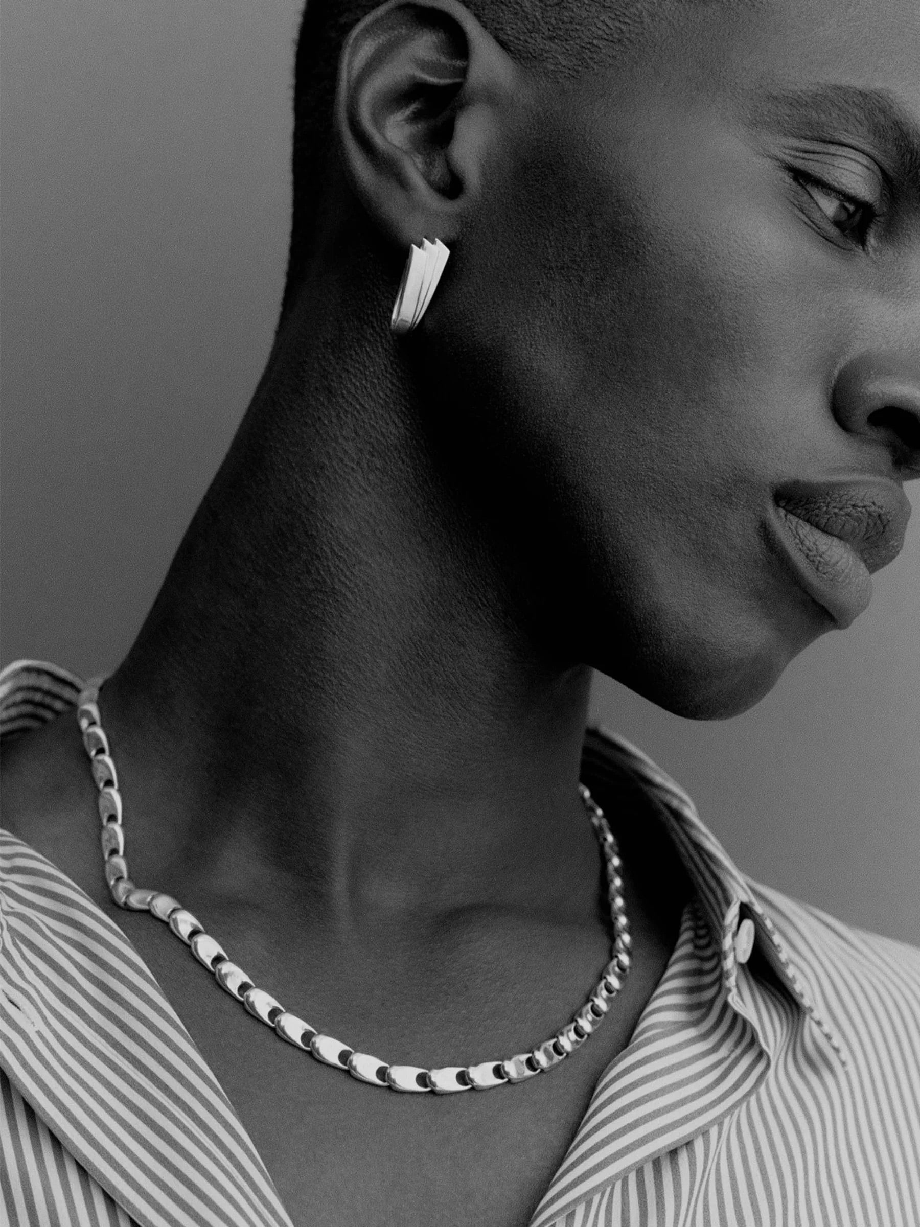 Model wearing Kinraden Symmetry Earrings in silver with polished folded shape and sculptural architectural design