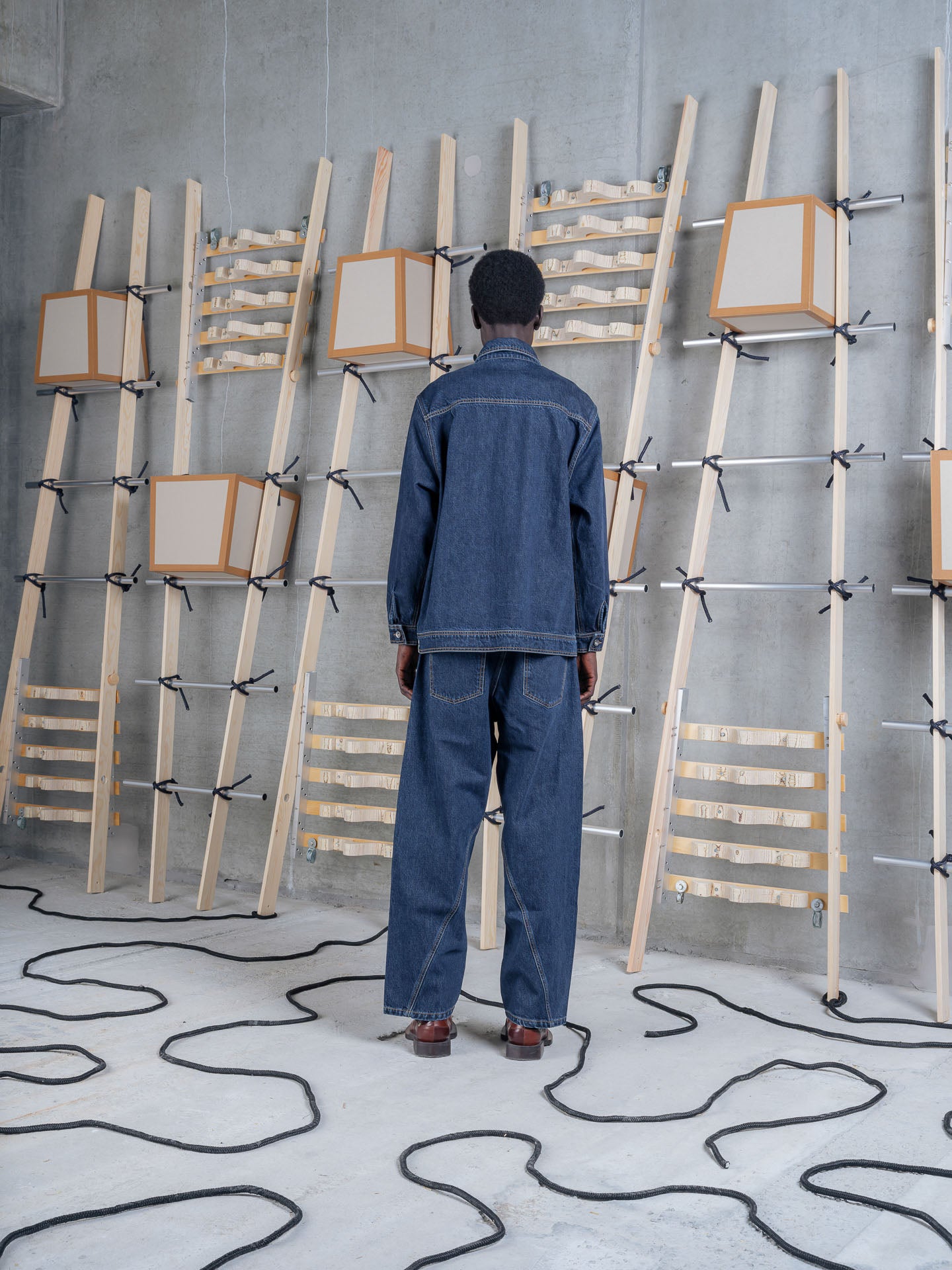 Model wearing Henrik Vibskov Mads Jacket in Rinse Denim back view
