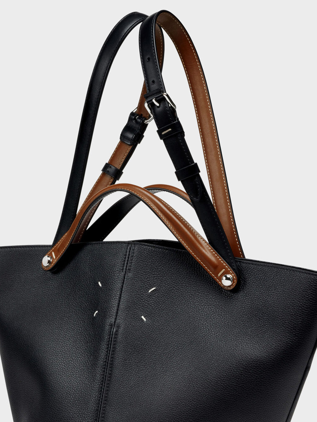 Close-up of Maison Margiela Dress-Age Medium showing dual-wear buckle strap system with black and chestnut calfskin contrast