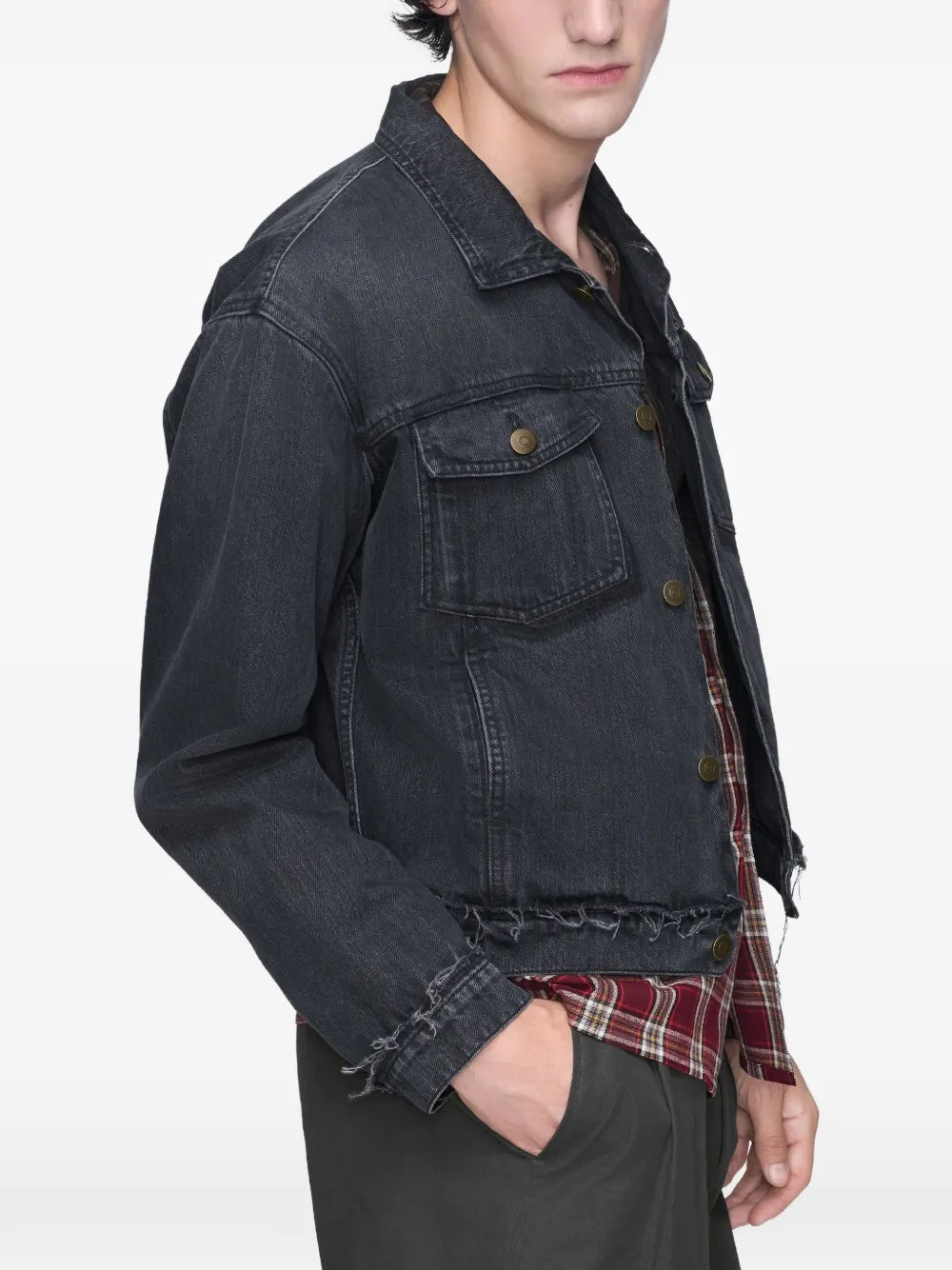 Close-up side view of the model wearing the washed black Maison Margiela jacket, focusing on the long sleeves, distressed texture, and cropped hem.