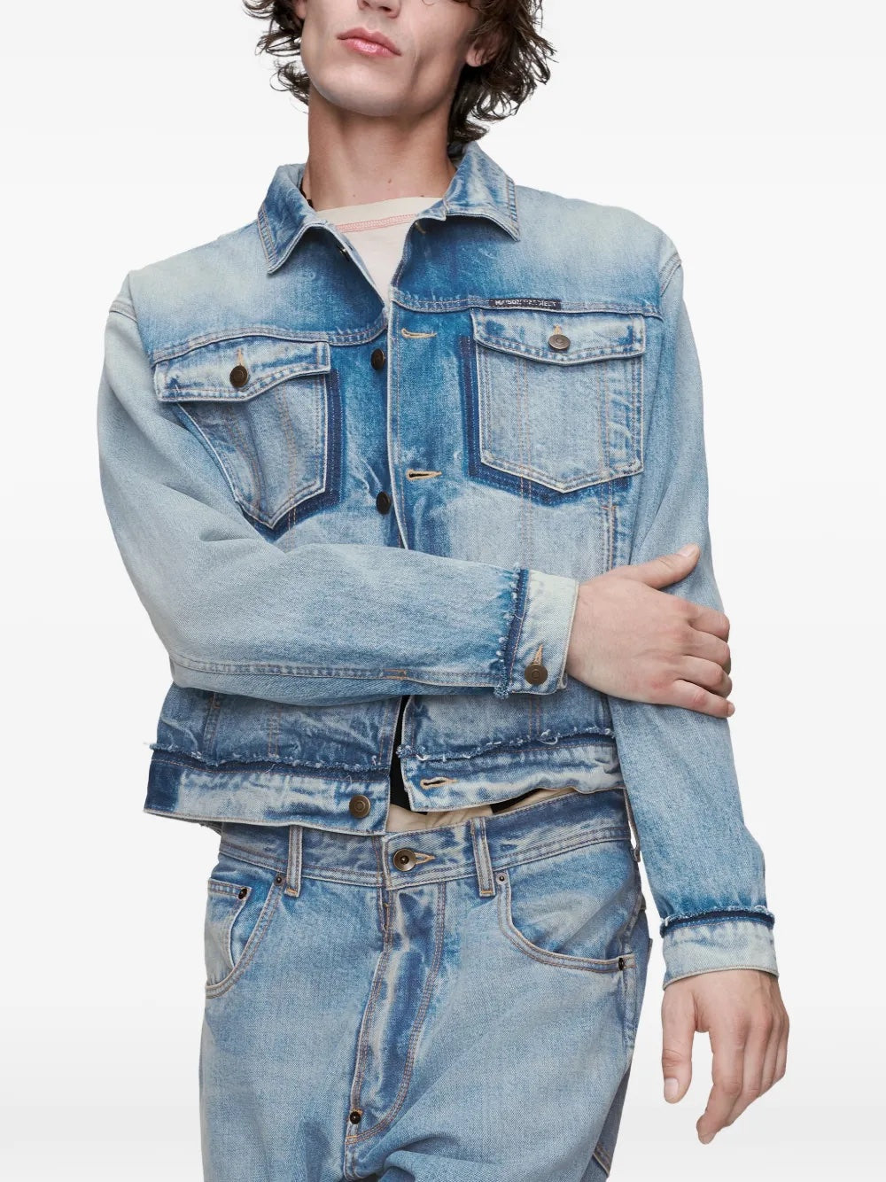 Close-up front view of the model wearing the Maison Margiela sports jacket, highlighting the washed blue denim, collar detail, and button closure.