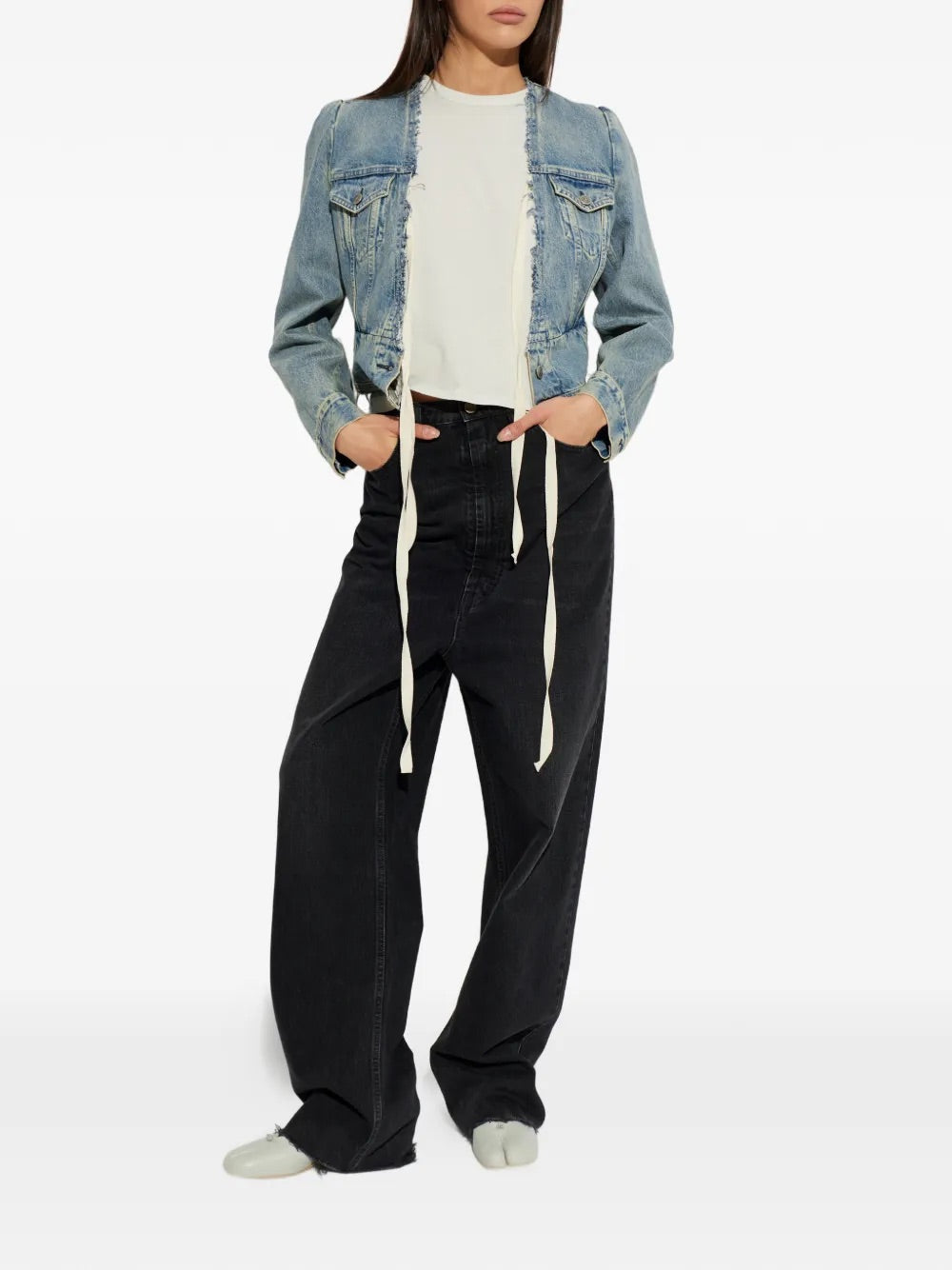 Model wearing Pants 5 Pockets in Medium Black by Maison Margiela, full-length front view of high-waist straight-leg faded black denim jeans with raw-cut hem and elongated silhouette, Spring/Summer 2026
