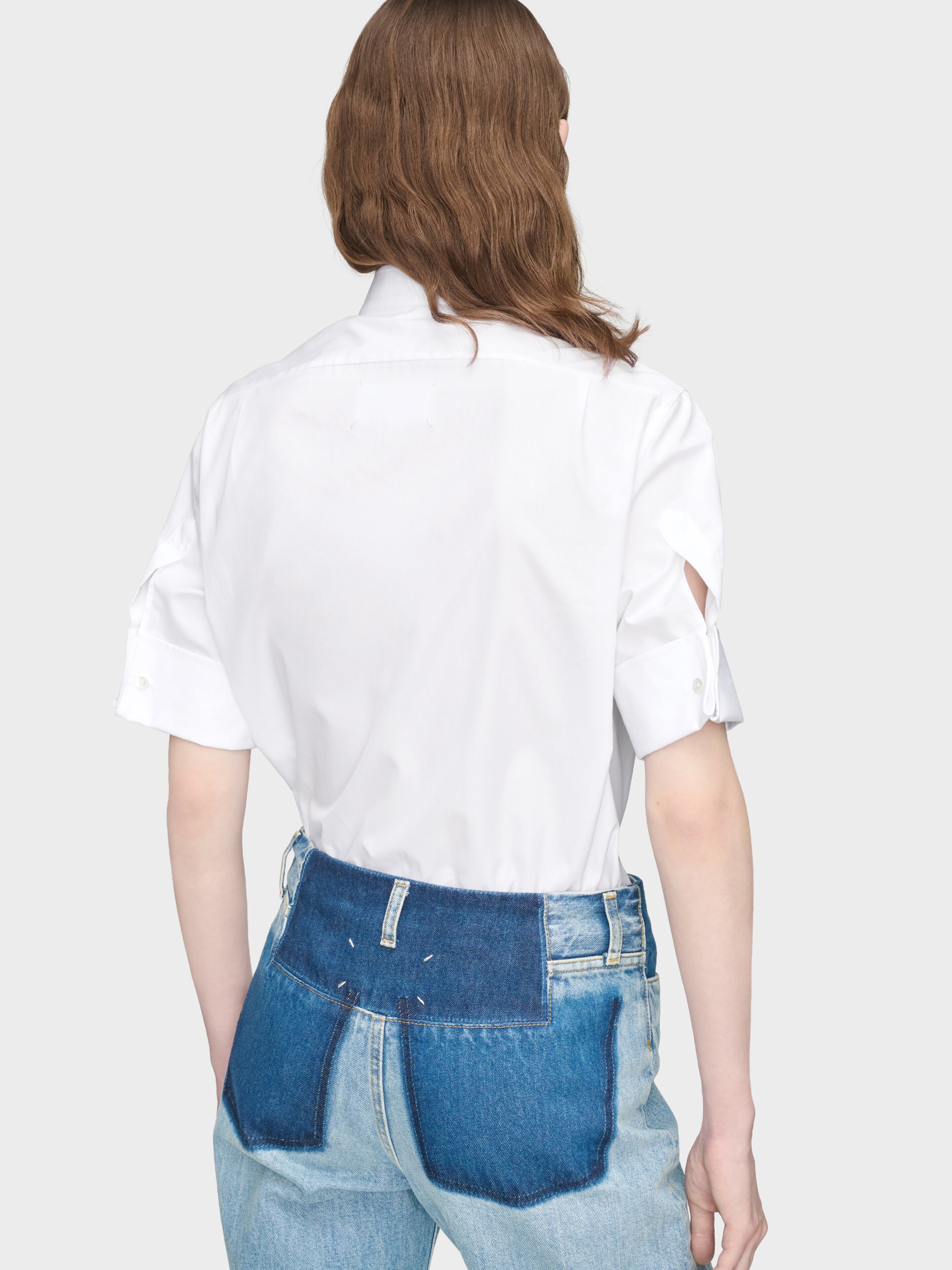 Maison Margiela Snapped Button Short Sleeves Shirt in White on-model back view, elongated hem, relaxed oversized fit, short sleeves with turn-back cuffs