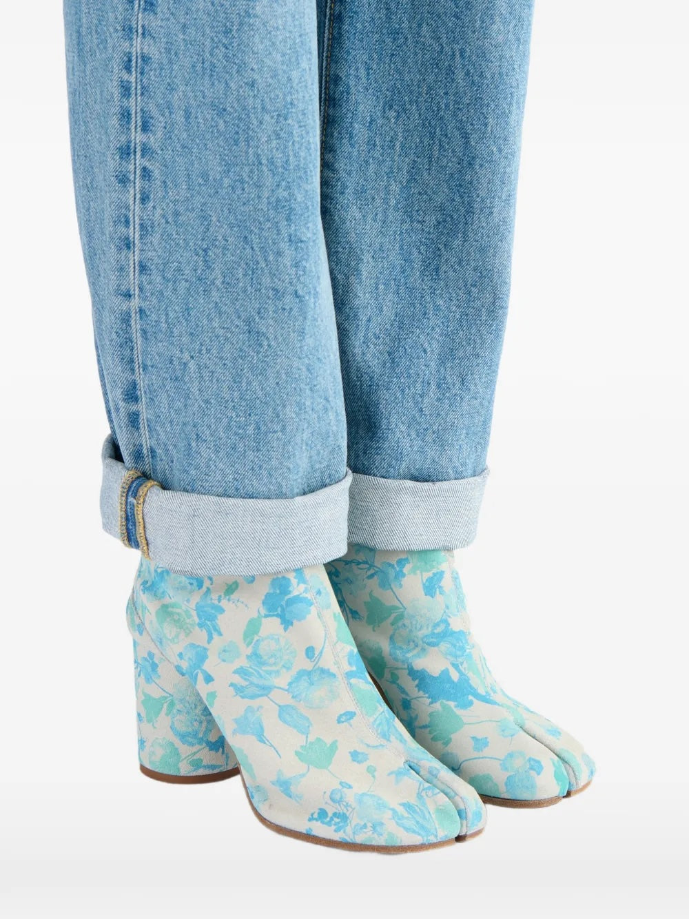 Maison Margiela Tabi Ankle Boot 80mm worn with cuffed light-wash jeans, styled on model to show the boot's ankle height, Tabi toe, and floral print against denim