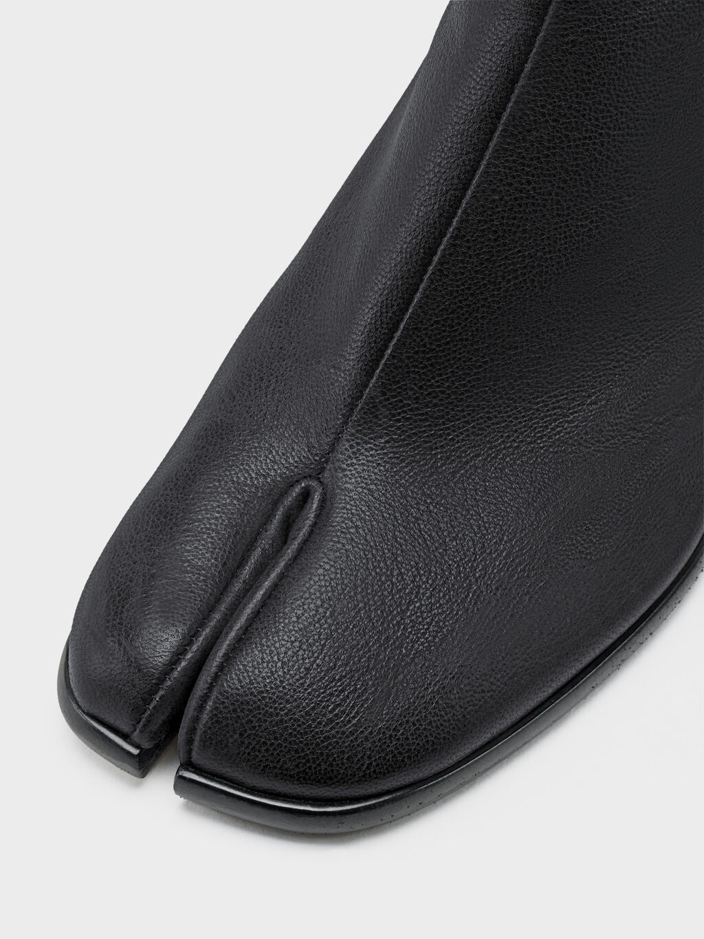 Maison Margiela Tabi Ankle Boot H60 in Black, close-up of signature split toe, smooth ovine leather upper, sculptural tabi silhouette detail