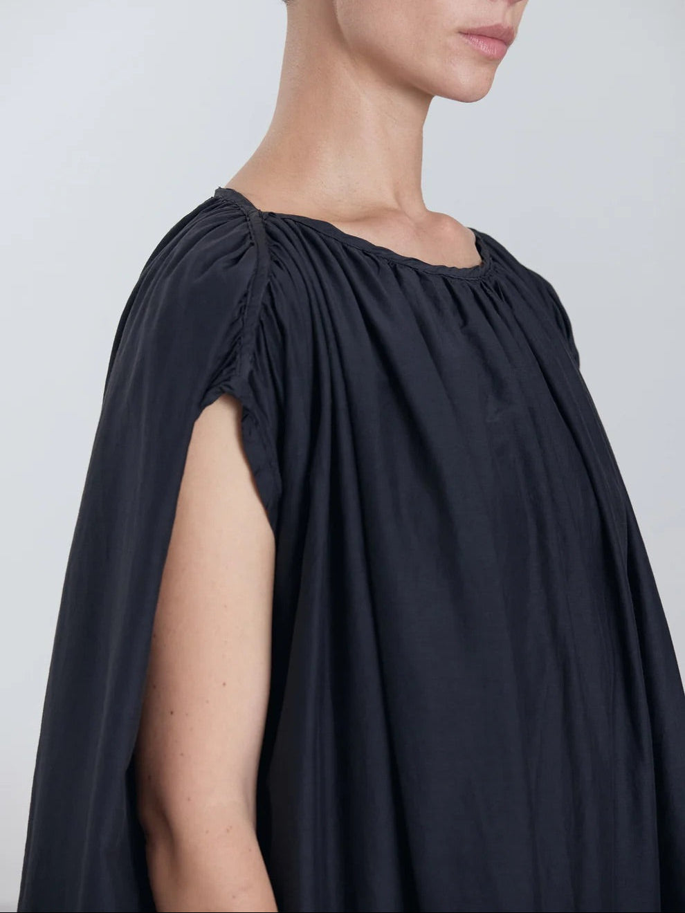 Black Crane Mont Blanc Dress in Faded Black - close portrait view on model showing shoulder piping and shirring detail