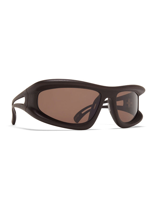 Mykita x 032c MARFA Sunglasses ebony brown, three-quarter angle revealing the deep wraparound frame volume, padded temple arms, and full coverage of the brown tinted lenses