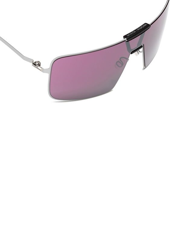 Mykita x Rimowa Navigator Sunshield MR004, close-up of the mulberry shield lens showing the co-branded "Mykita | Rimowa" text on the nose bridge and etched logo detail on the lens