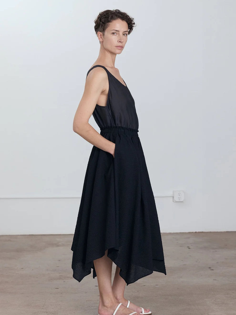 Black Crane Paper Skirt in Midnight - side view on model showing four-panel construction and asymmetric hem