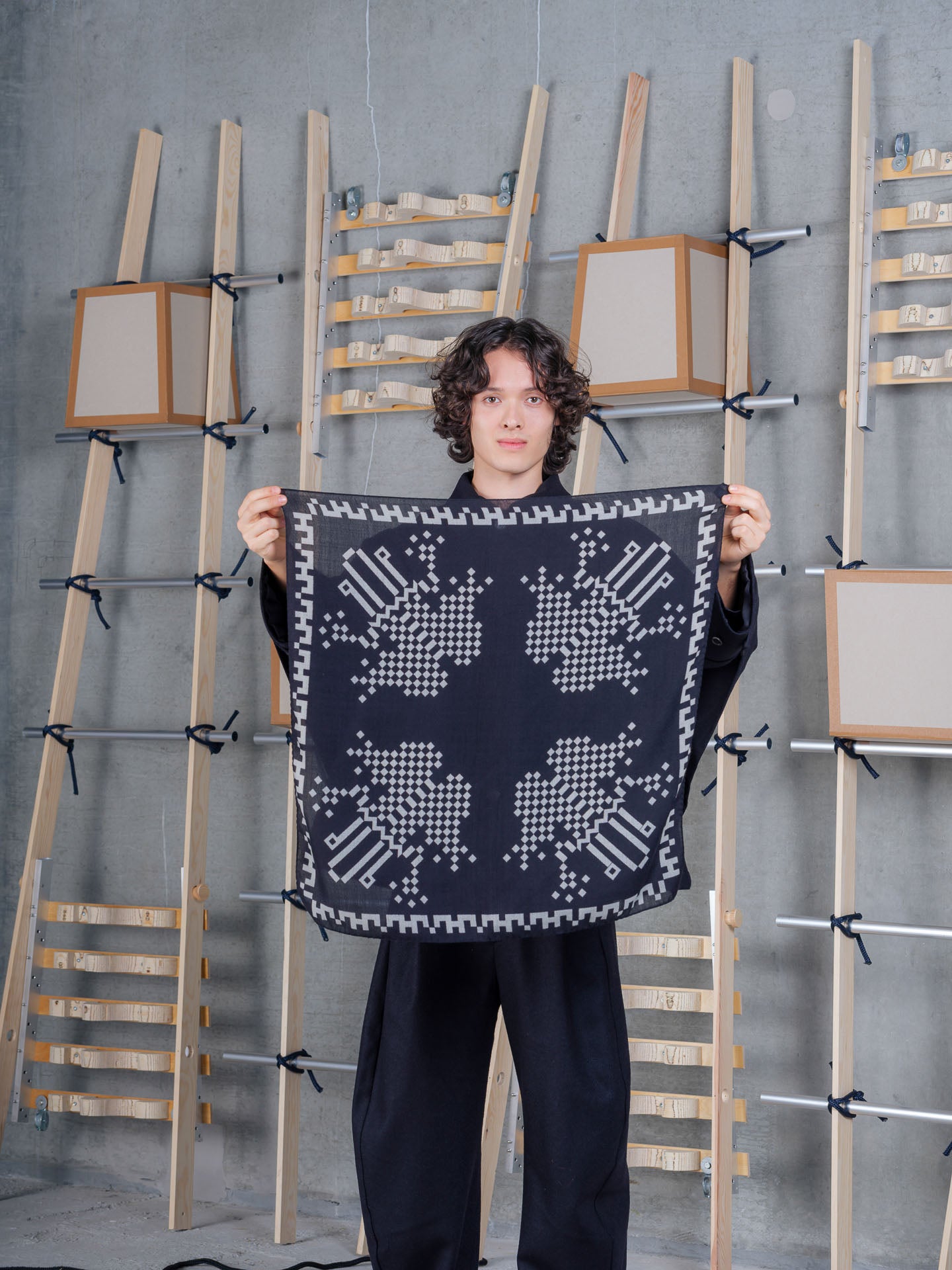 Model holding Pixel Frog Wool Scarf in Pixelated Black Frog by Henrik Vibskov
