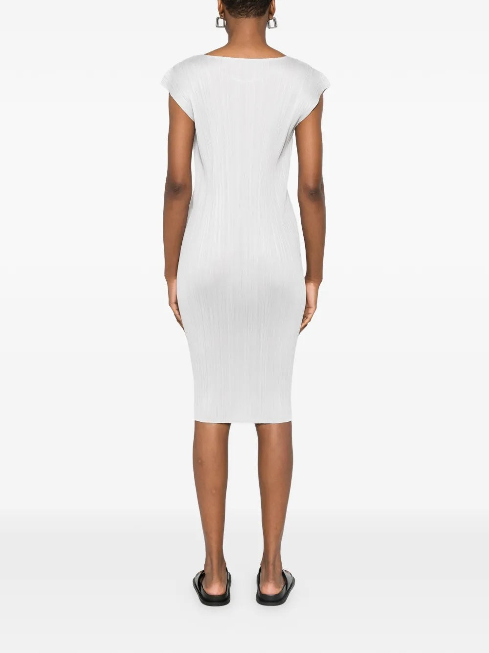 Back view of model wearing the light grey, short sleeves, pleated dress from Pleats Please Issey Miyake on a white background