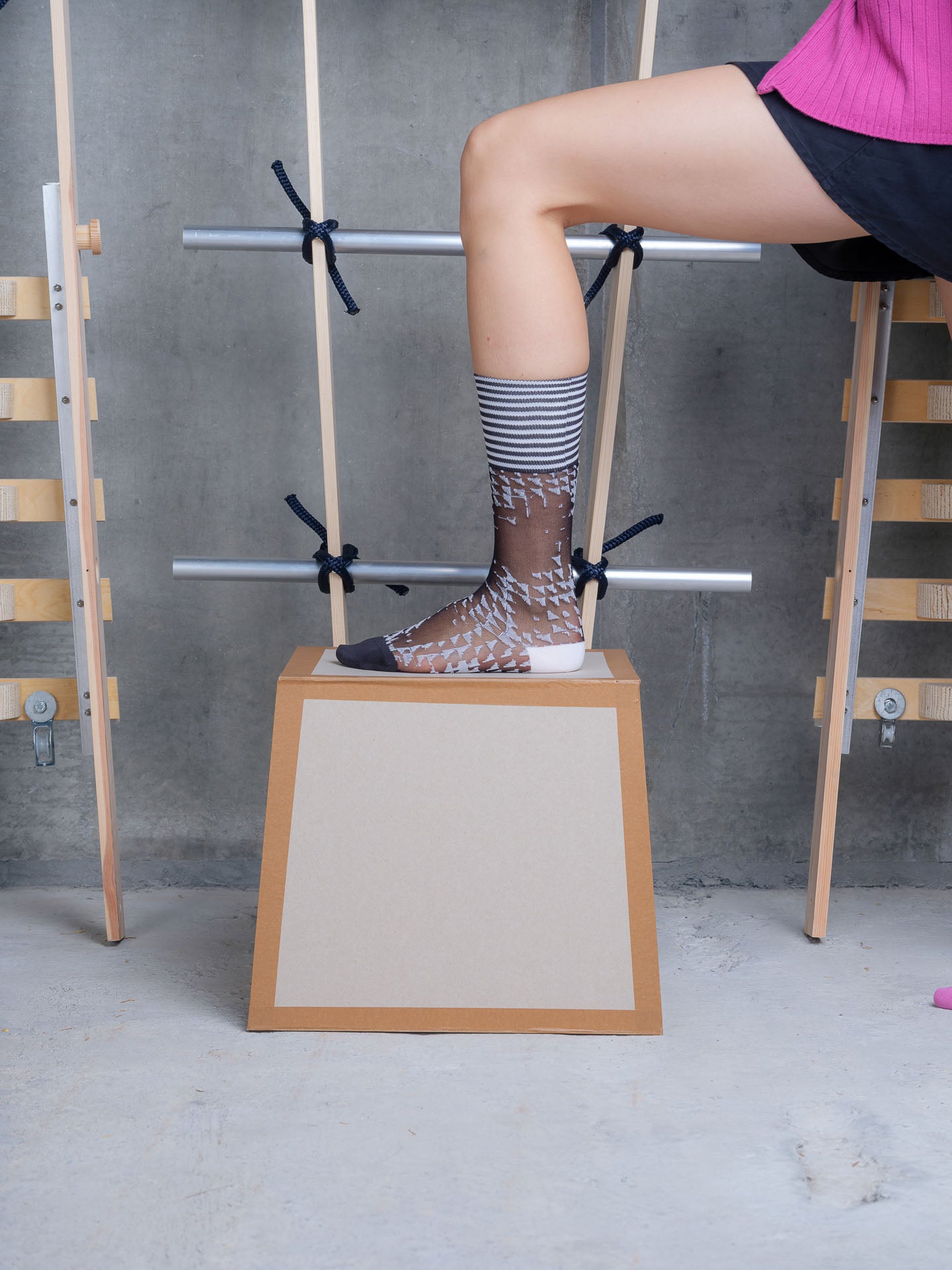 Model wearing Puzzle Knee Sock in Black White Tiles by Henrik Vibskov