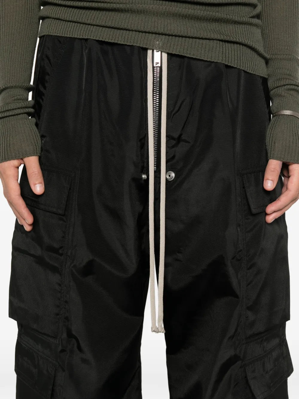 Close up of the black cargo pants with long drawstrings from Rick Owens DRKSHDW on a white background