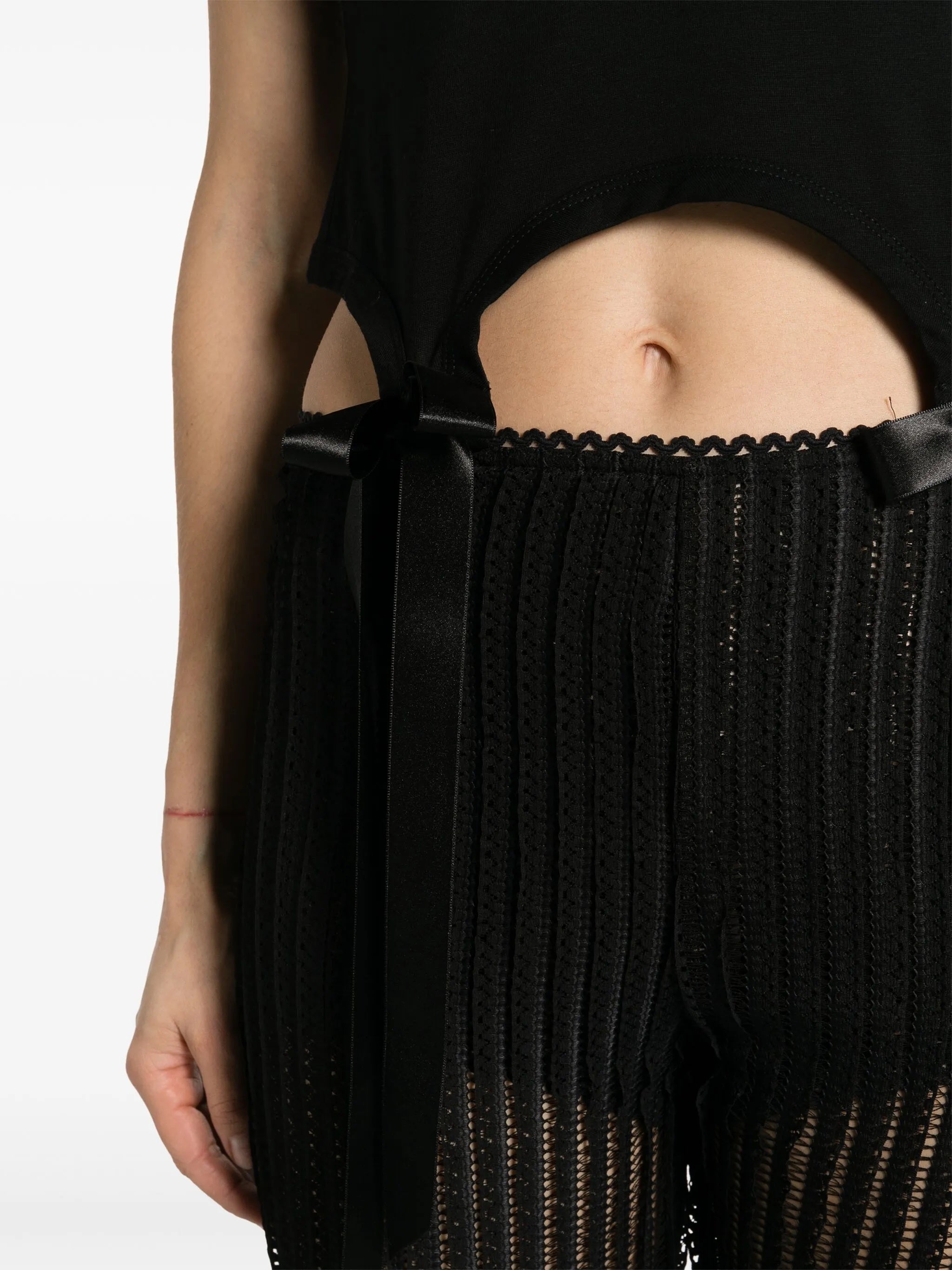 Person wearing a black outfit with a ribbed texture and thin straps.