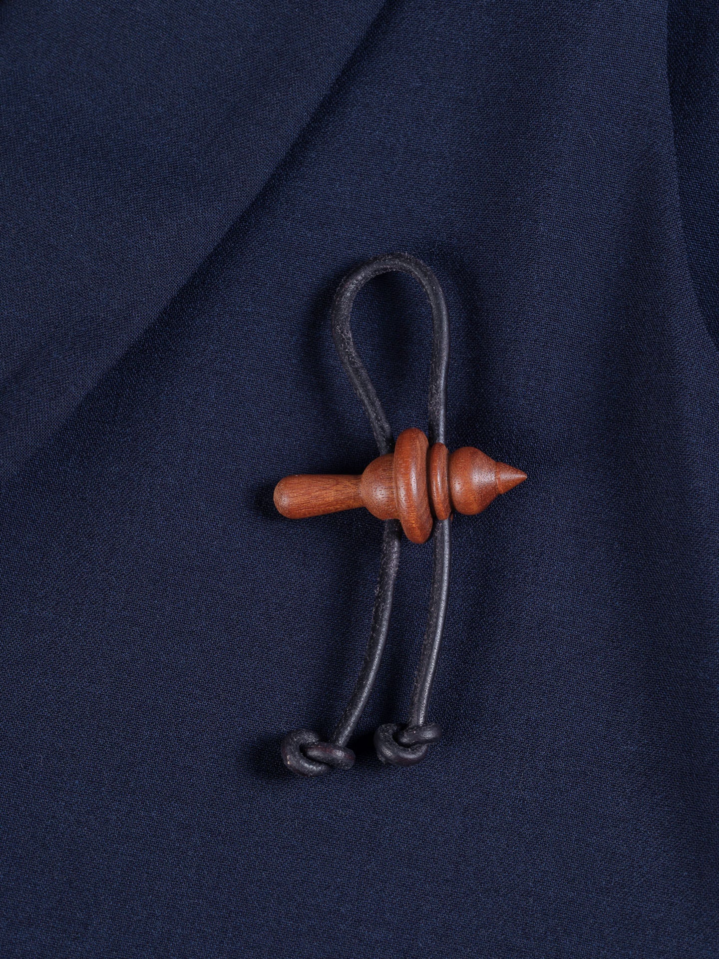Spinner Brooch in Wood by Henrik Vibskov worn on navy fabric