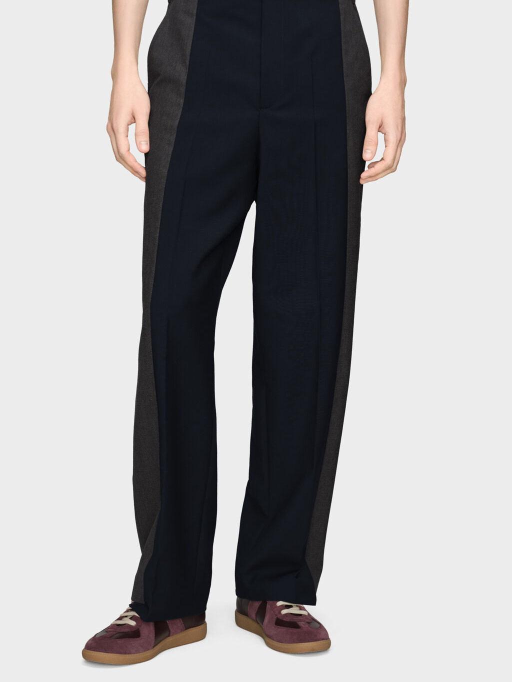 Model wearing Maison Margiela Spliced Tailored Trousers in Dark Blue/Charcoal