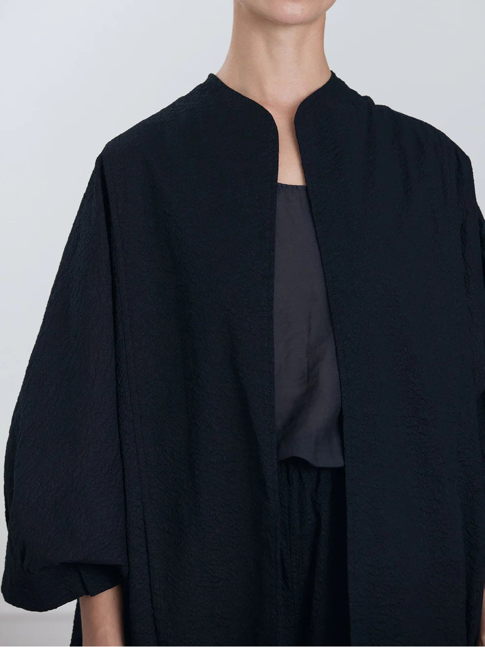 Black Crane Spoon Jacket in Midnight - close portrait view on model showing open front and ripple textured fabric