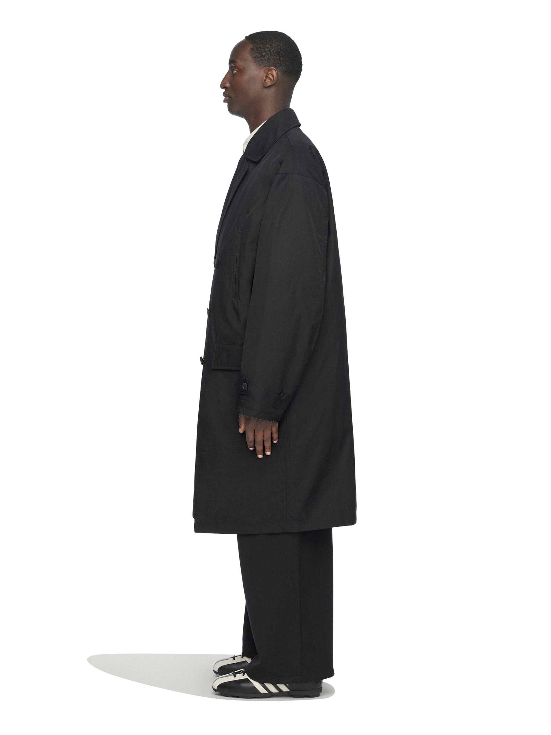 Side view of the model wearing the Y-3 Spun Nylon Cabban Coat in Black.