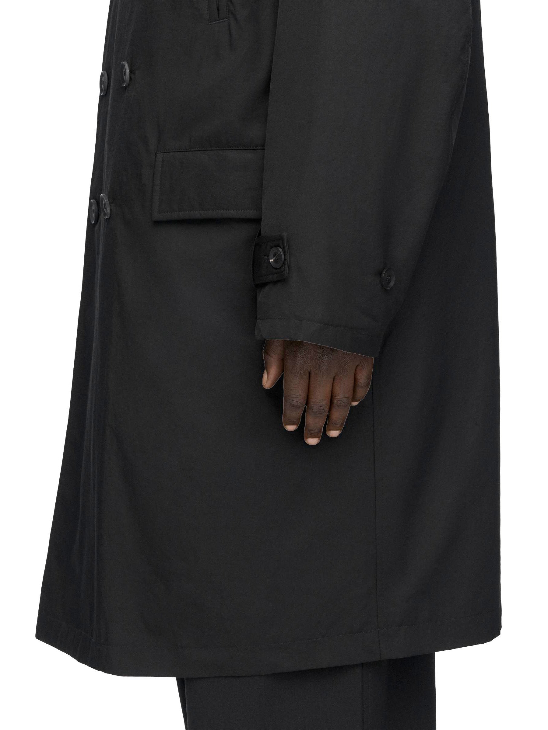 Detail of the sleeve and pocket construction on the Y-3 Spun Nylon Cabban Coat in Black.