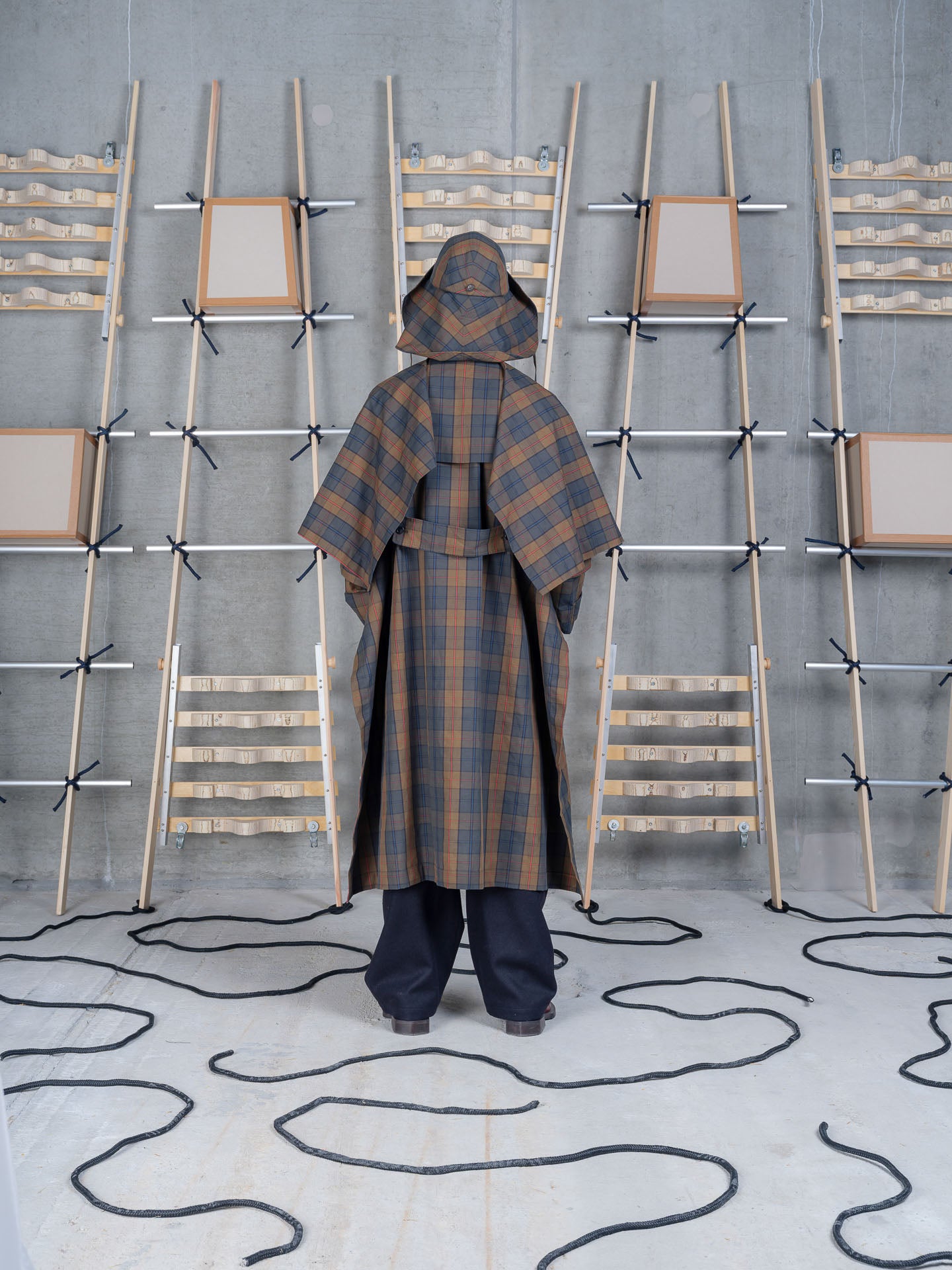 Henrik Vibskov Uncut Coat in Tartan Dry Wax worn back view with hood
