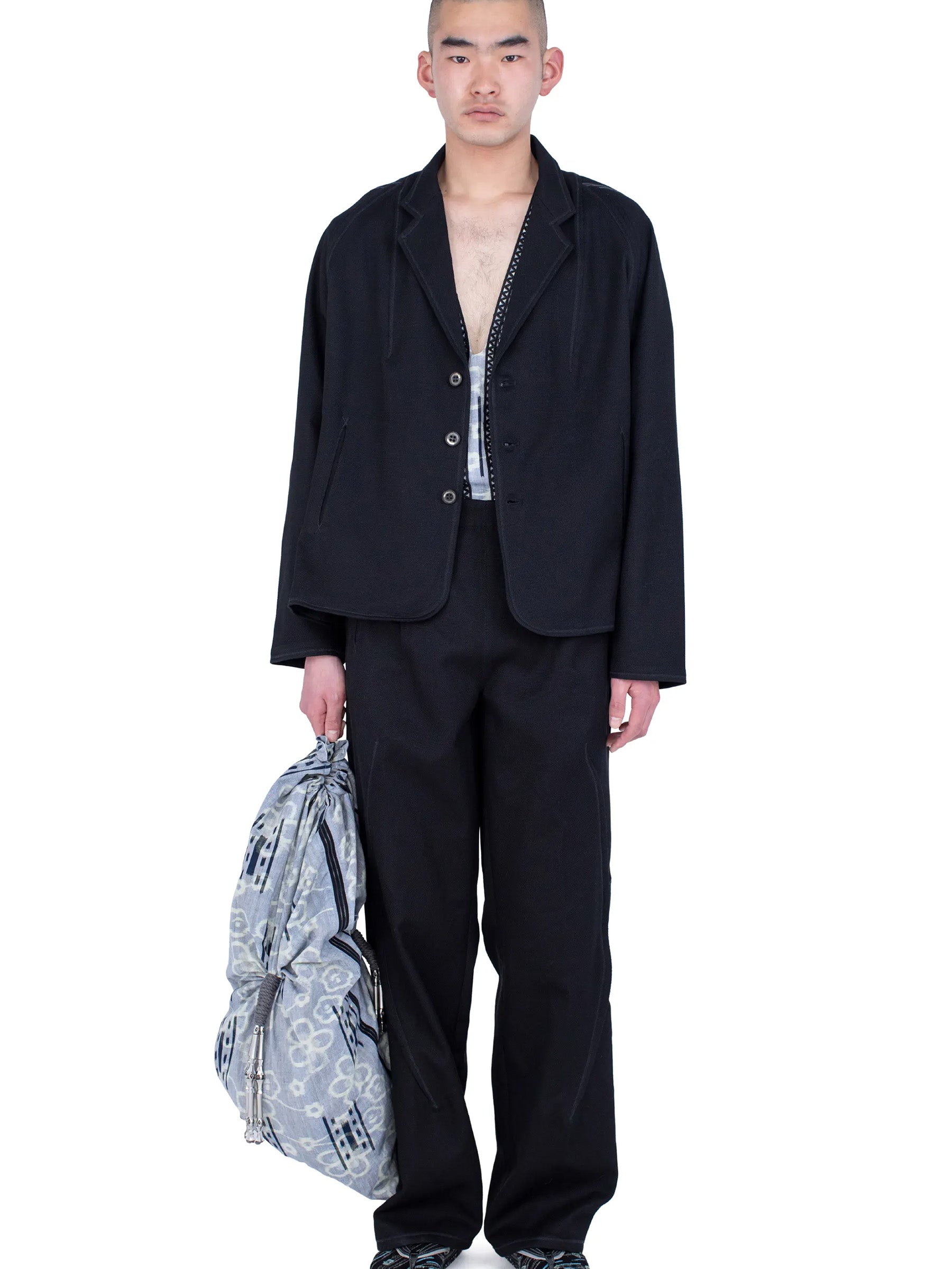 Model wearing the Kiko Kostadinov Vig K-Dart Blazer in Space Black with matching trousers.