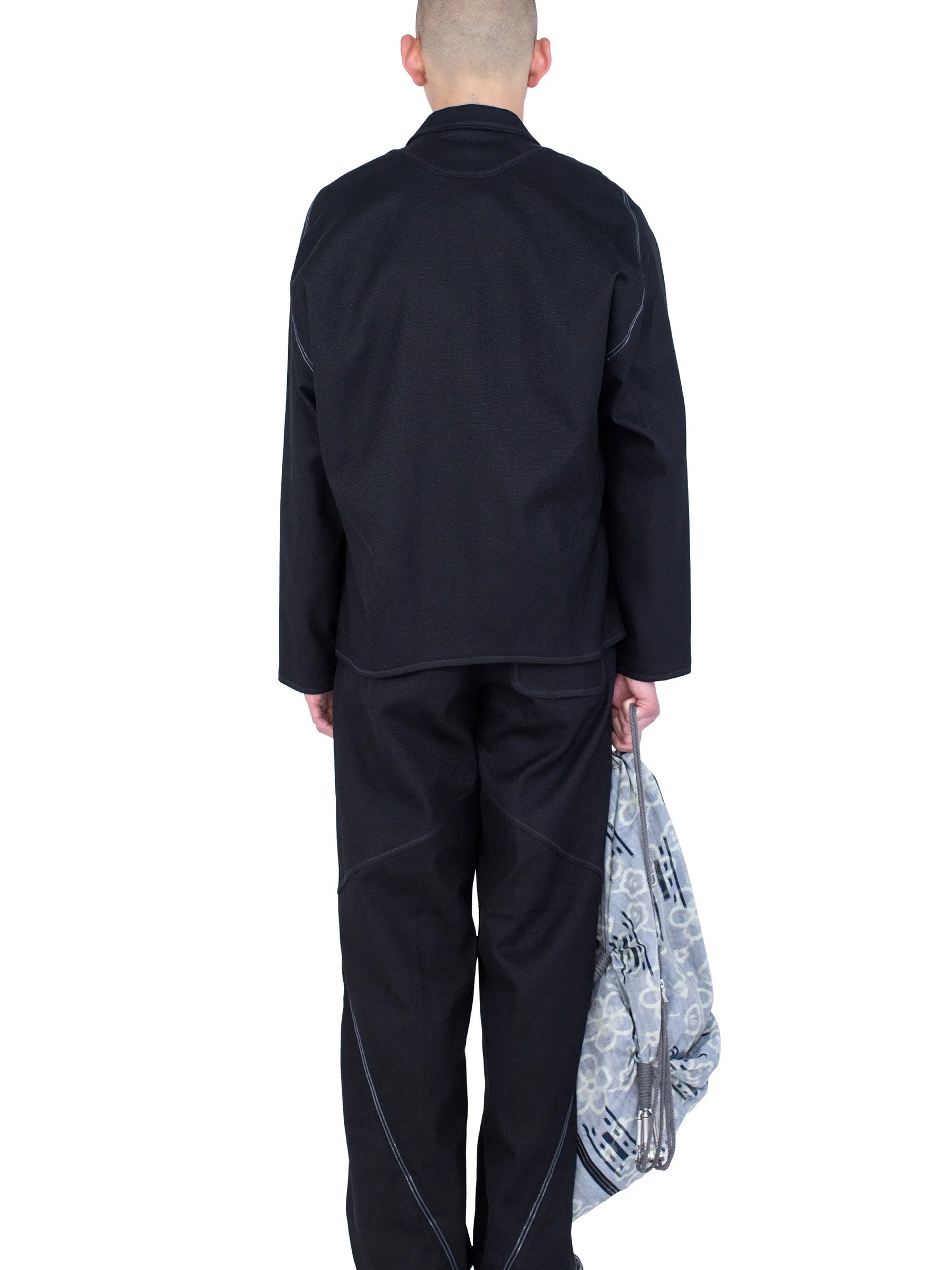 Rear view of the model wearing the Kiko Kostadinov Vig K-Dart Blazer in Space Black.