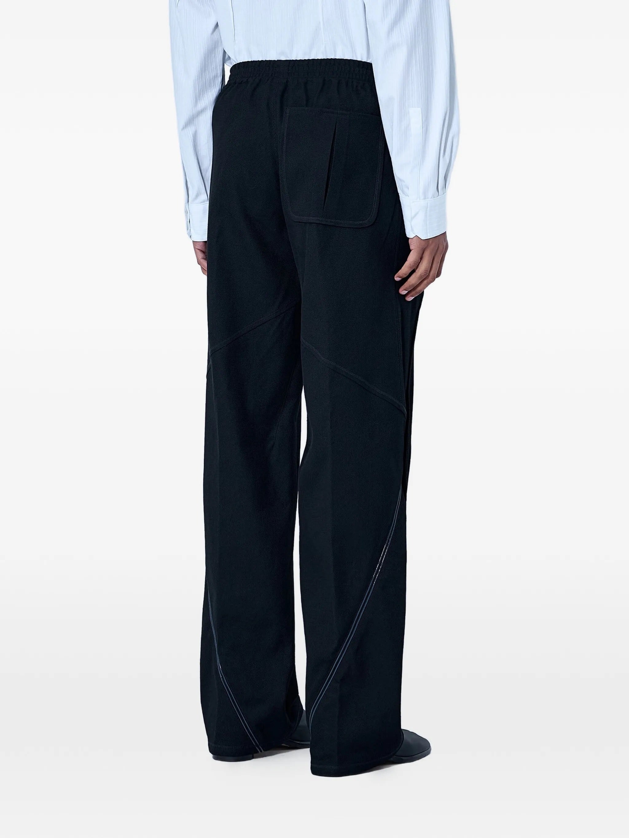 Rear view of the model wearing the Kiko Kostadinov Vig K-Dart Trouser in Space Black.