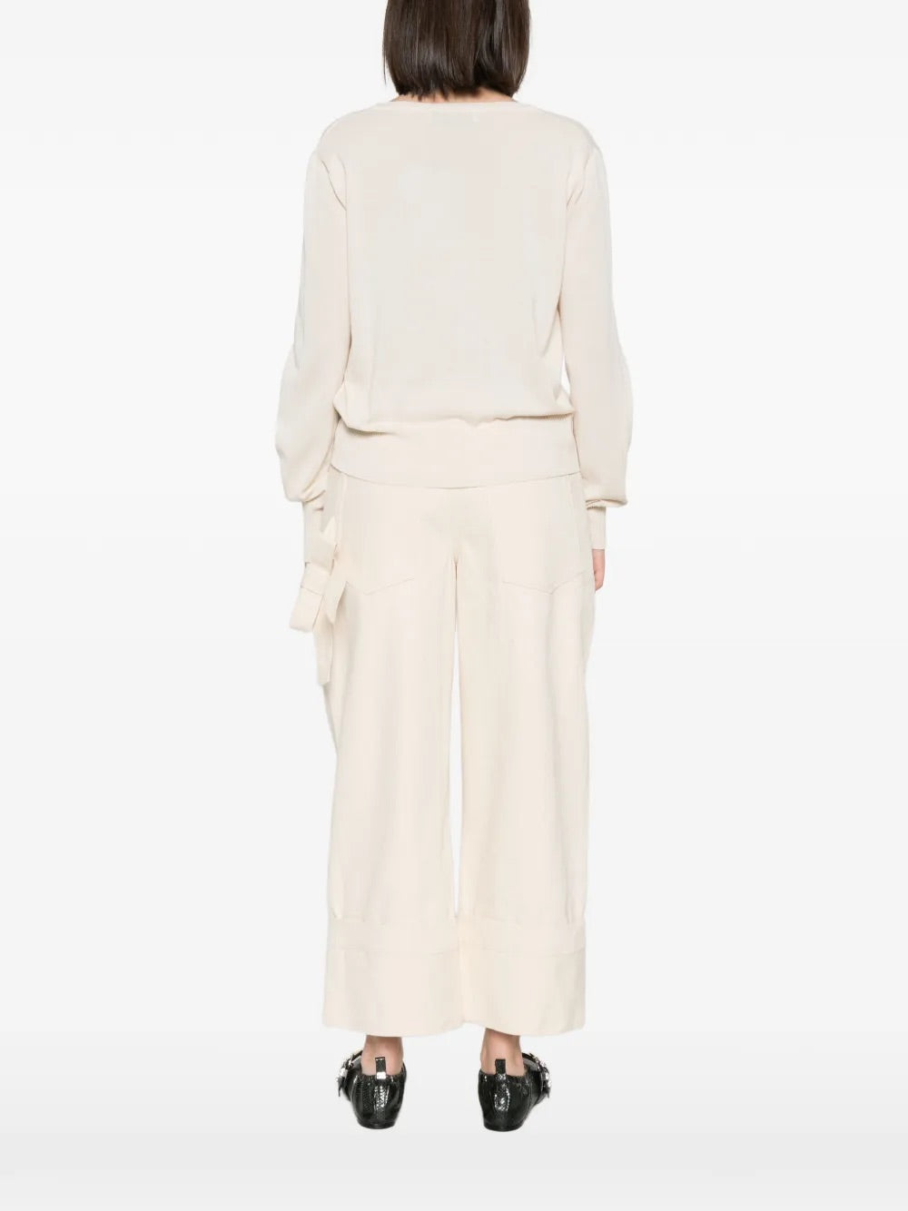 Model wearing Pamela Jumper in Cream by Vivienne Westwood, full-length back view of relaxed-fit cream cotton jumper with long sleeves and ribbed hem, Spring/Summer 2026