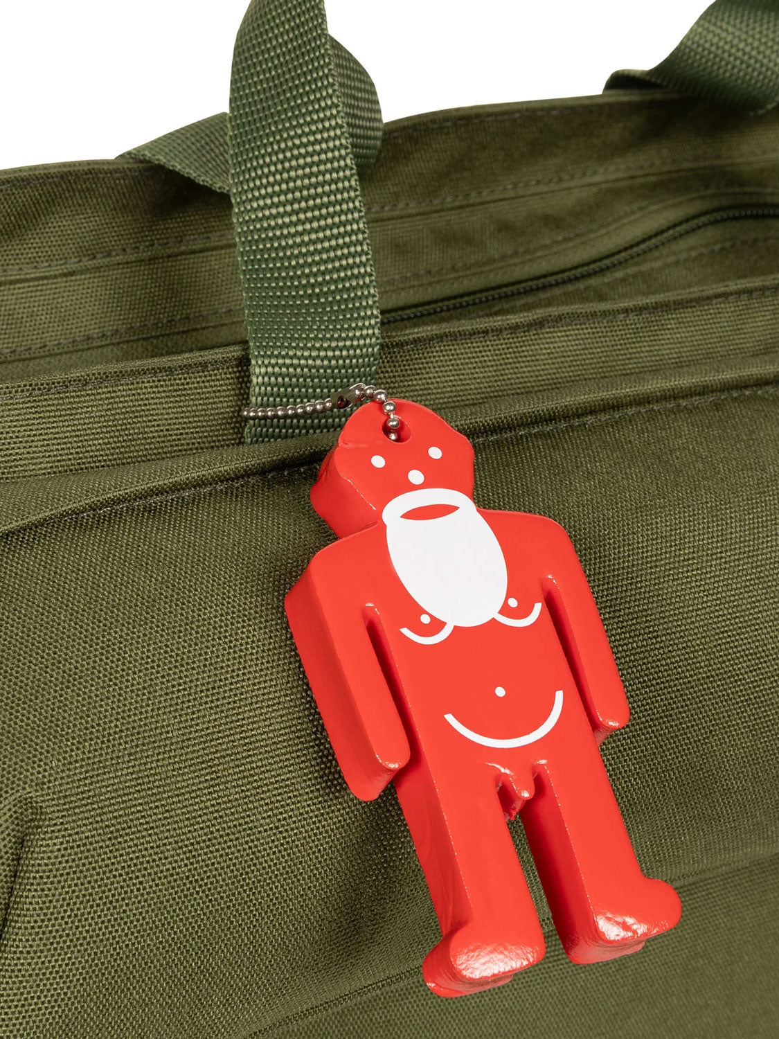 Close-up of red Walterman charm attached to Walter Van Beirendonck x Eastpak Walter Carry Bag