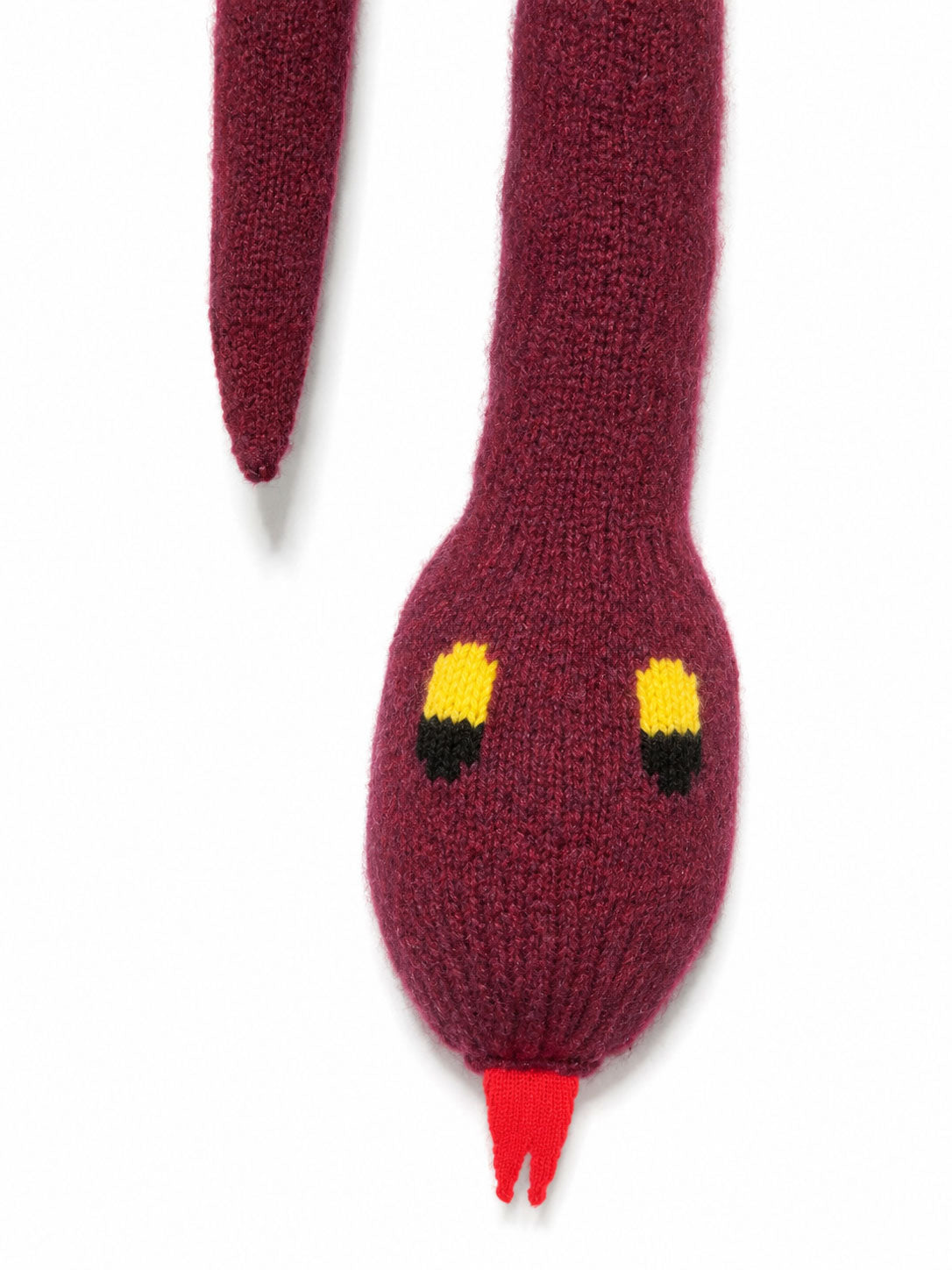 Close-up of the Walter Van Beirendonck Snake Scarf in Bordeaux showing the knitted snake head, yellow and black eyes and red tongue.