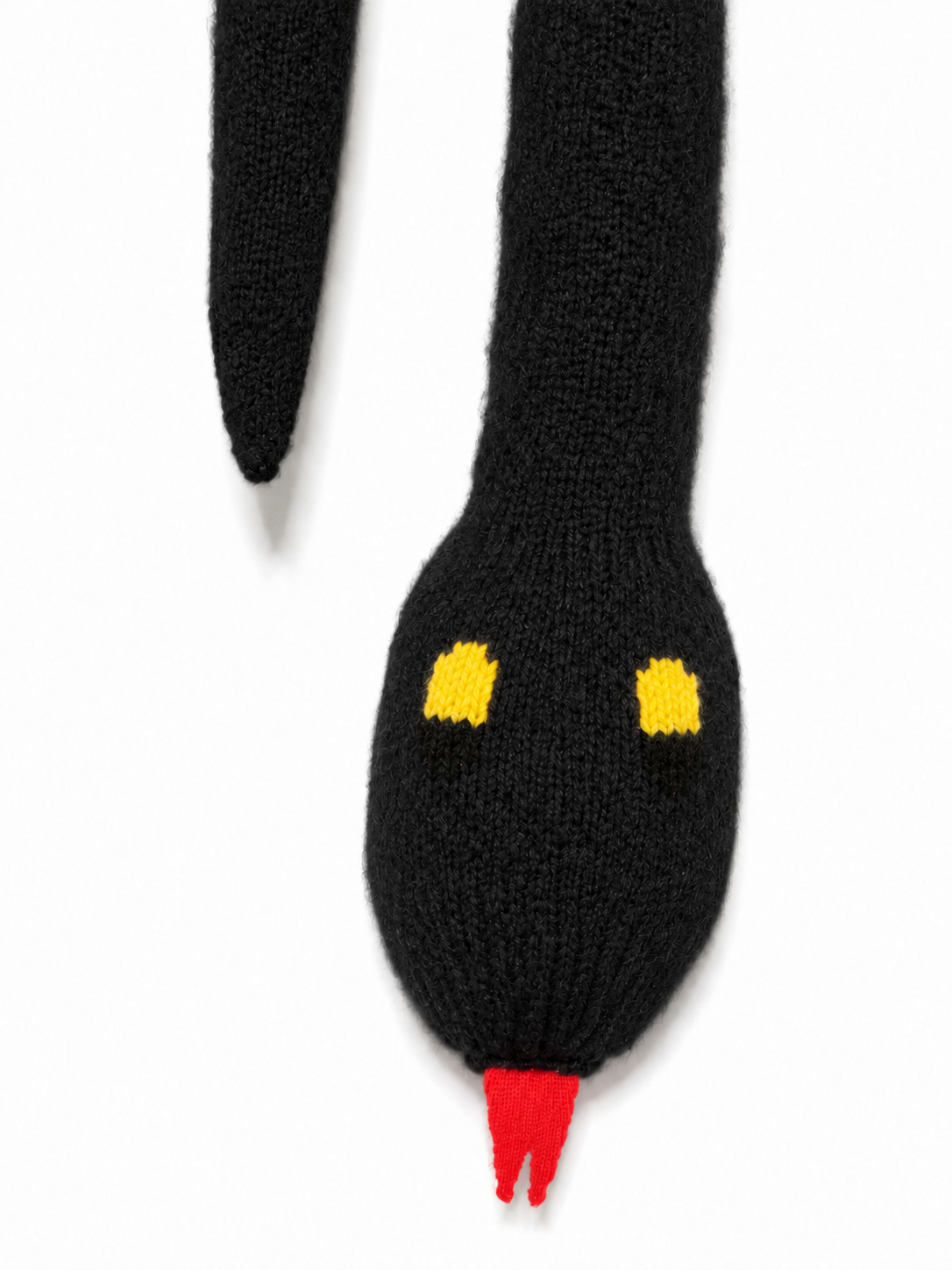 Close-up of the Walter Van Beirendonck Snake Scarf in Black showing the knitted snake head, yellow and black eyes and red tongue.