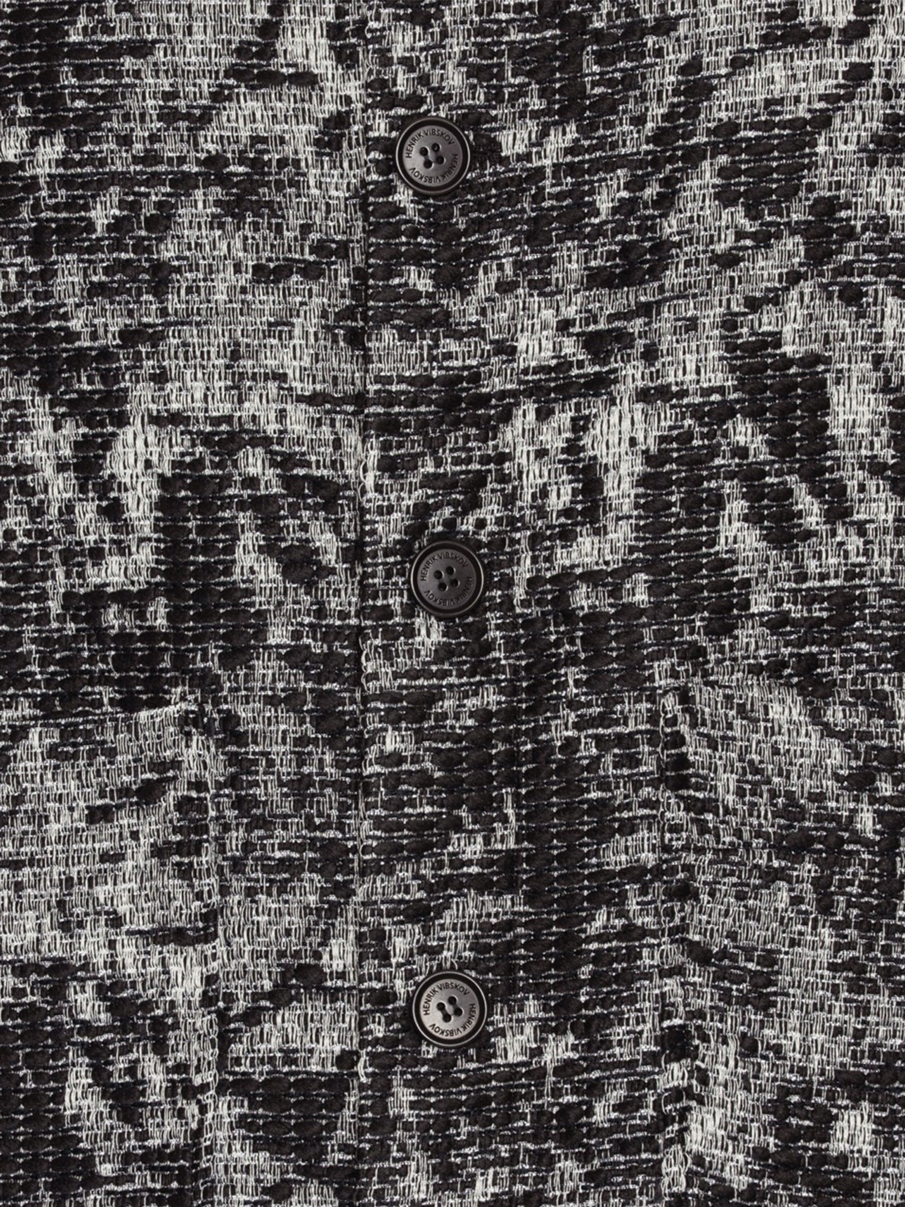 Close-up of Henrik Vibskov Wheel Jacket in Black 3D White textured fabric.