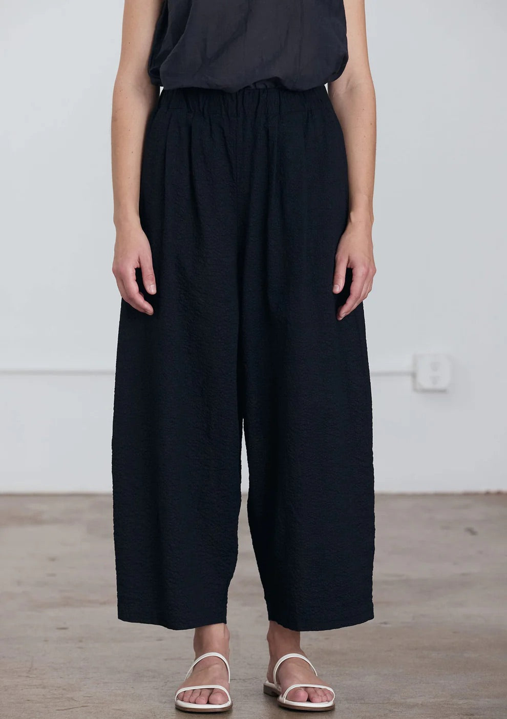 Black Crane Wide Pants in Midnight - front view on model showing waistband and wide leg detail