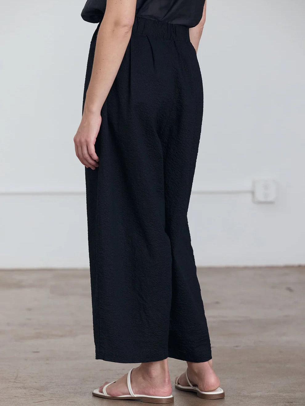 Black Crane Wide Pants in Midnight - side view on model showing wide leg and relaxed regular fit