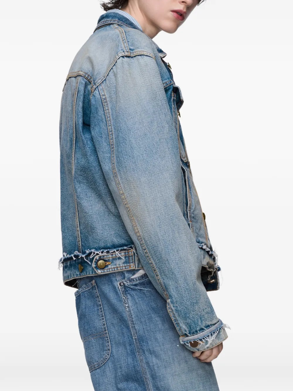Side close-up of a female model wearing the Maison Margiela Women’s Sports Jacket in Light Blue Indigo, emphasizing the sleeve structure, frayed edges, and soft cotton fabric.