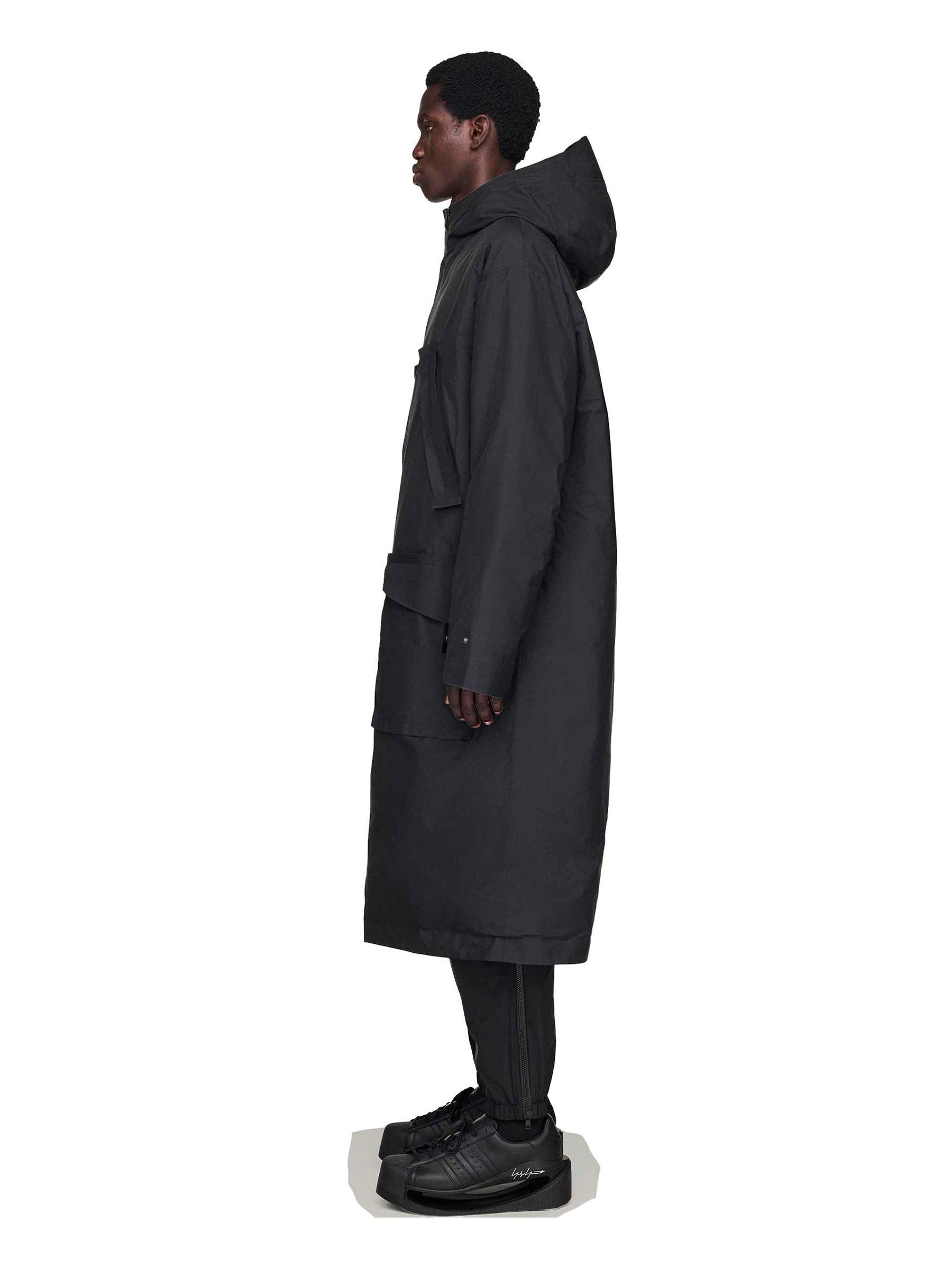 Person wearing a black coat with hoodie from Y- 3 on a white background