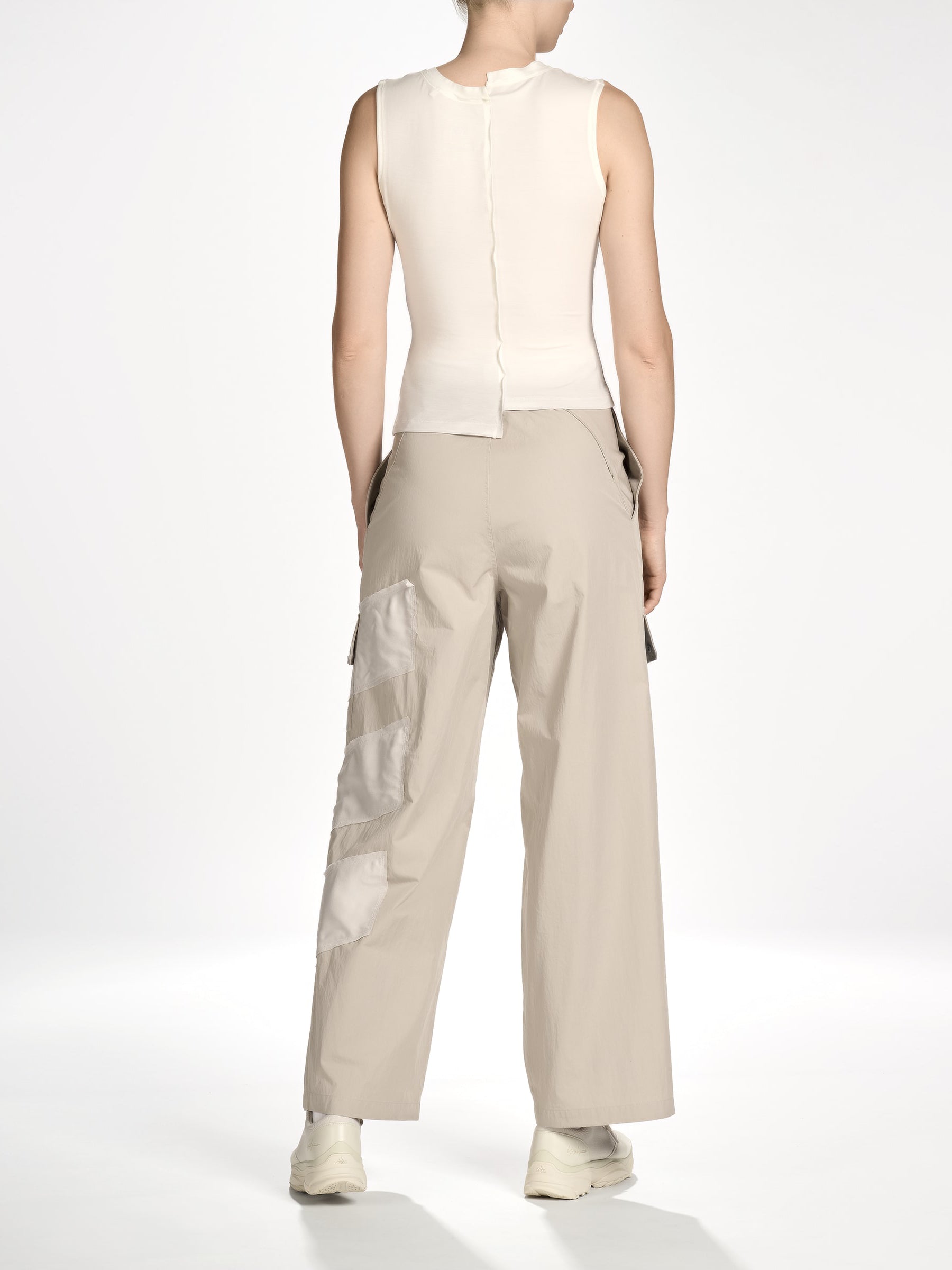 Back view of a female model wearing the Women’s Knit Double-Dye Tank in Beige from Y-3, displaying the dip-dye finish and clean back silhouette.